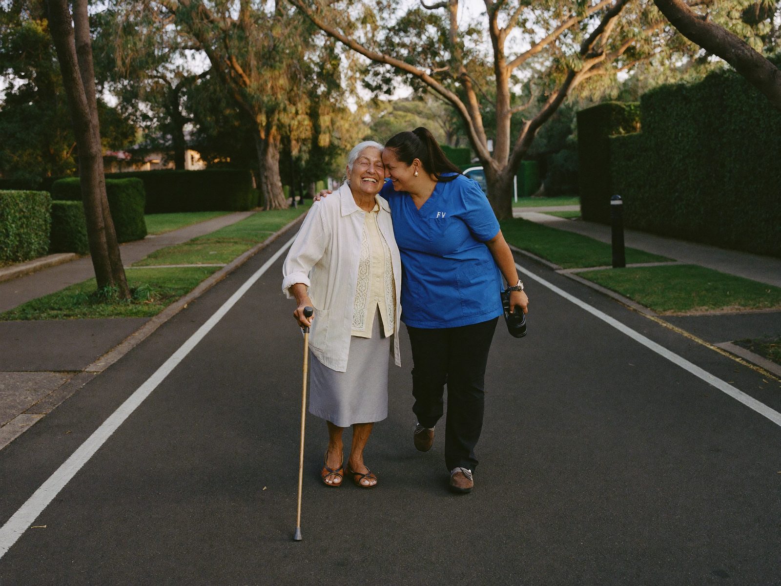 A Divine Care support worker sharing a cup of tea with an older client in her sunlit living room