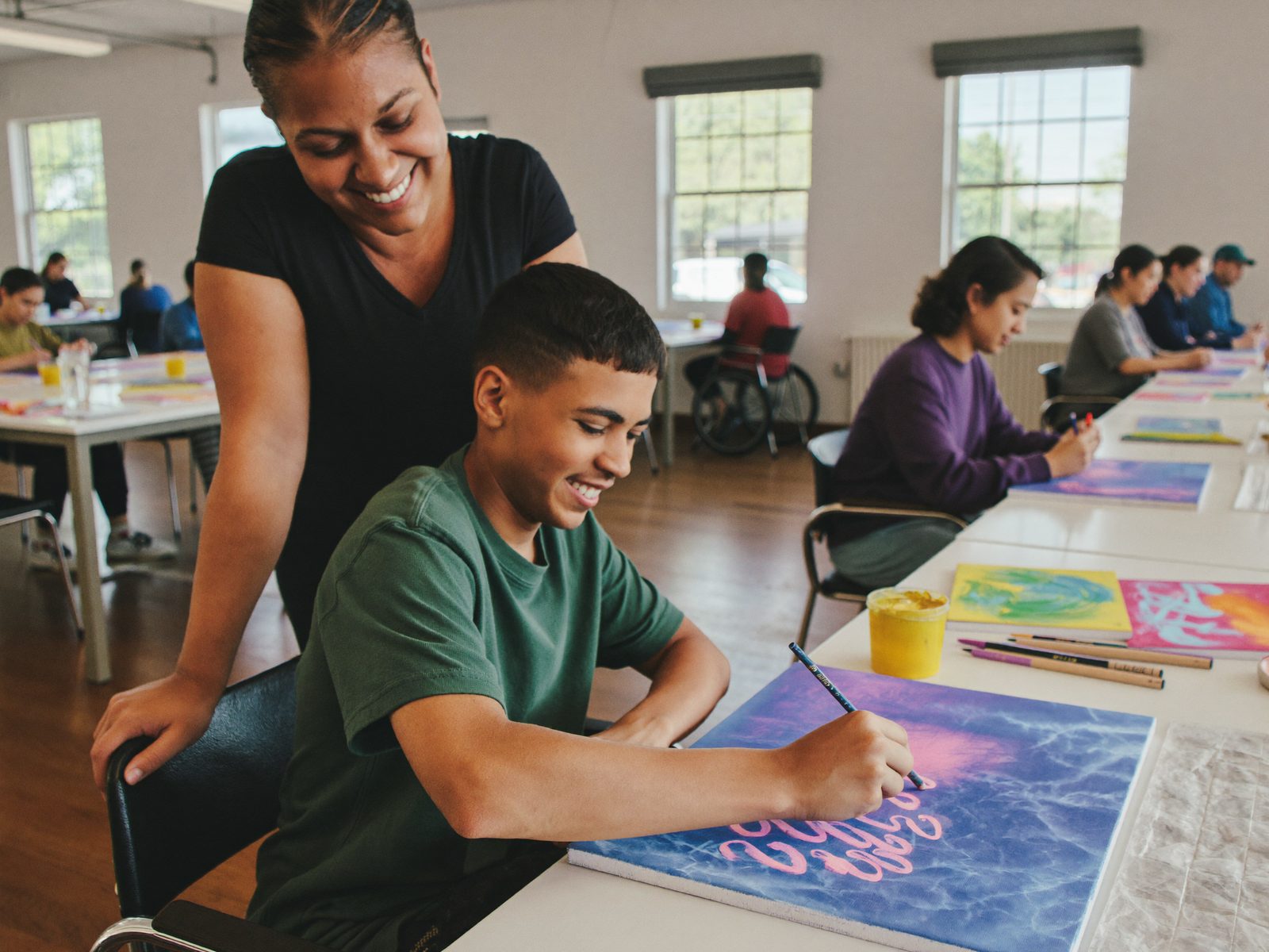 Participants and support workers taking part in a community art activity