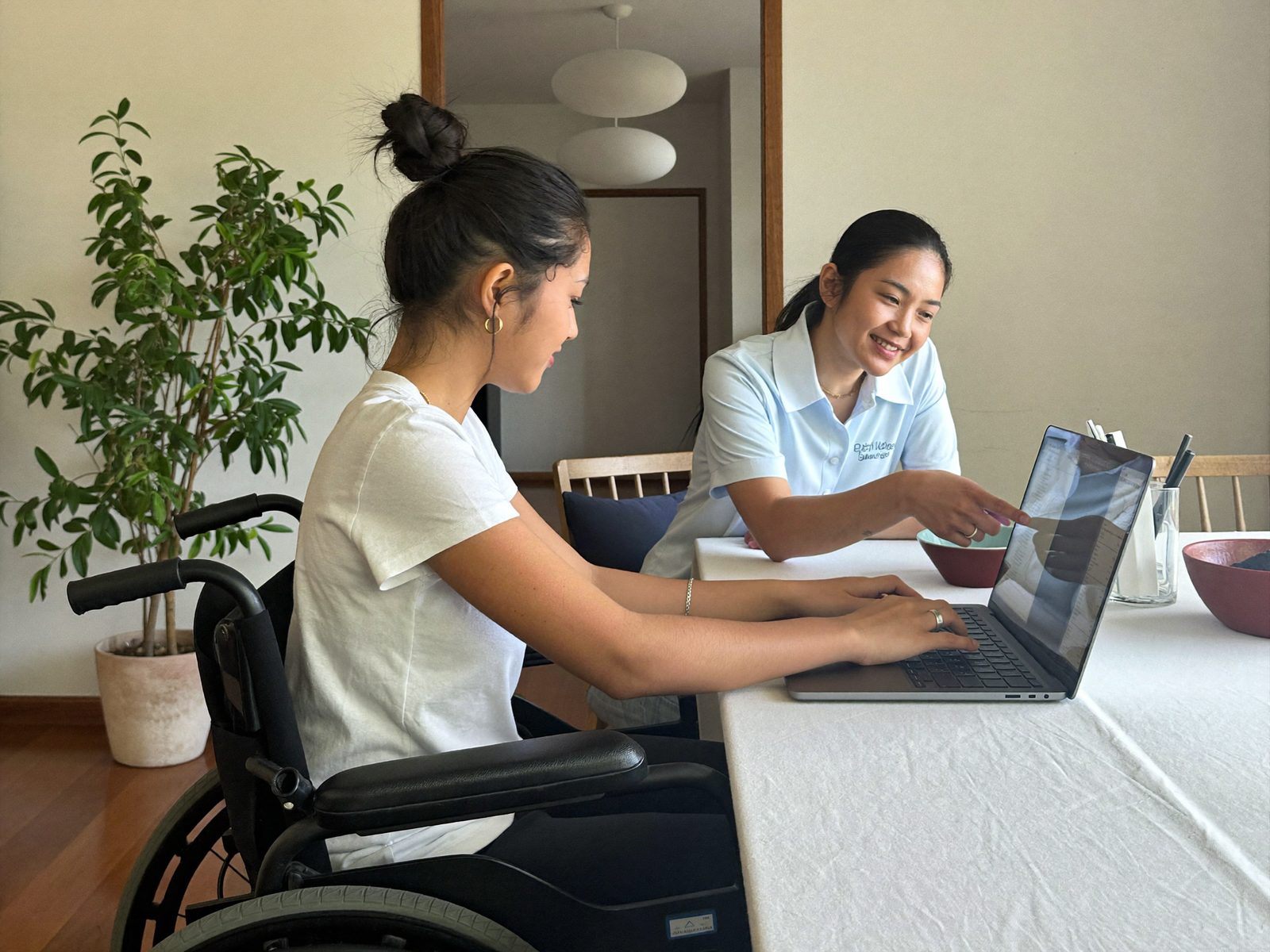 A support worker and an NDIS participant planning goals together at the kitchen table